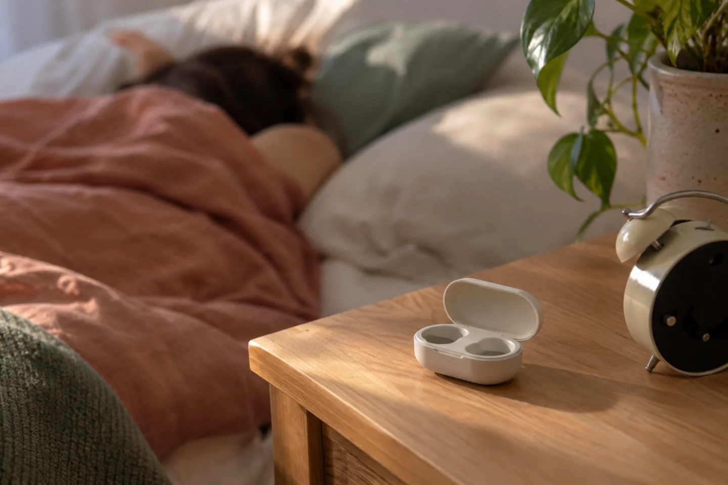Boîte propre sur une étagère de chevet près d’un réveil dont le cadran est caché