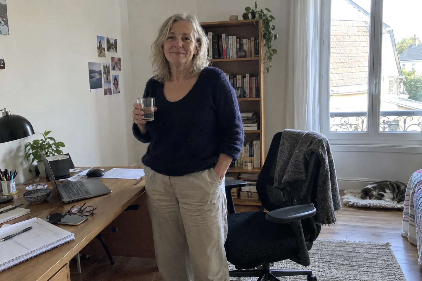 Une femme se tient près de son bureau après une pause.