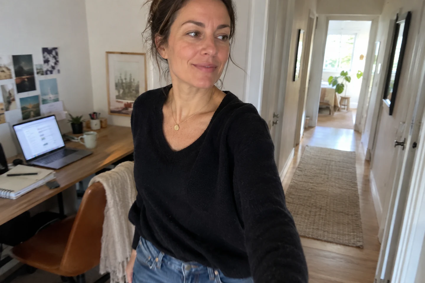 Une femme quitte son bureau et marche dans un couloir lumineux.